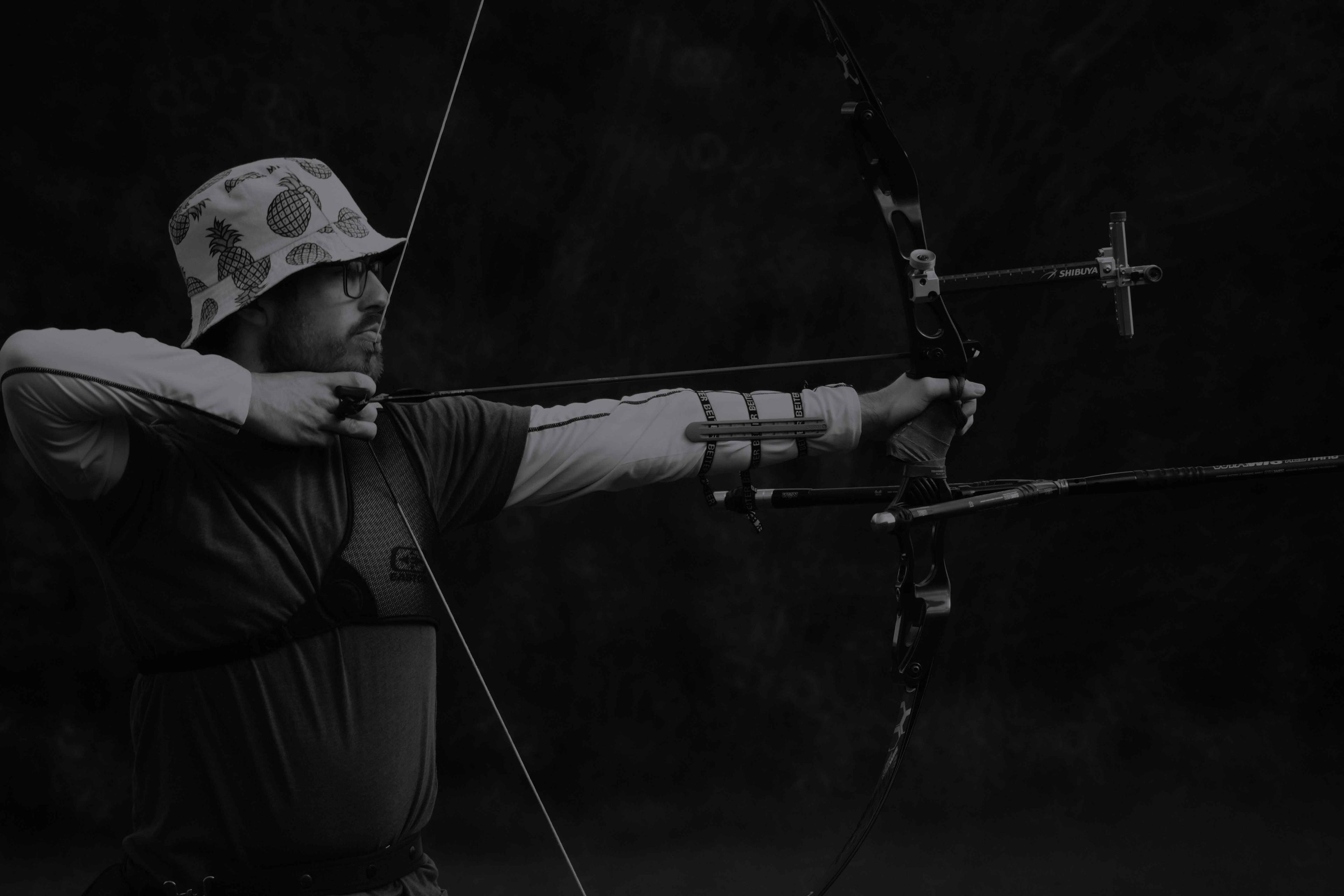 Recurve archer with sight aiming at target